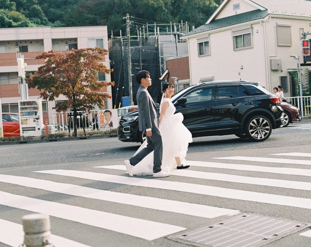 横断歩道を歩く新郎新婦