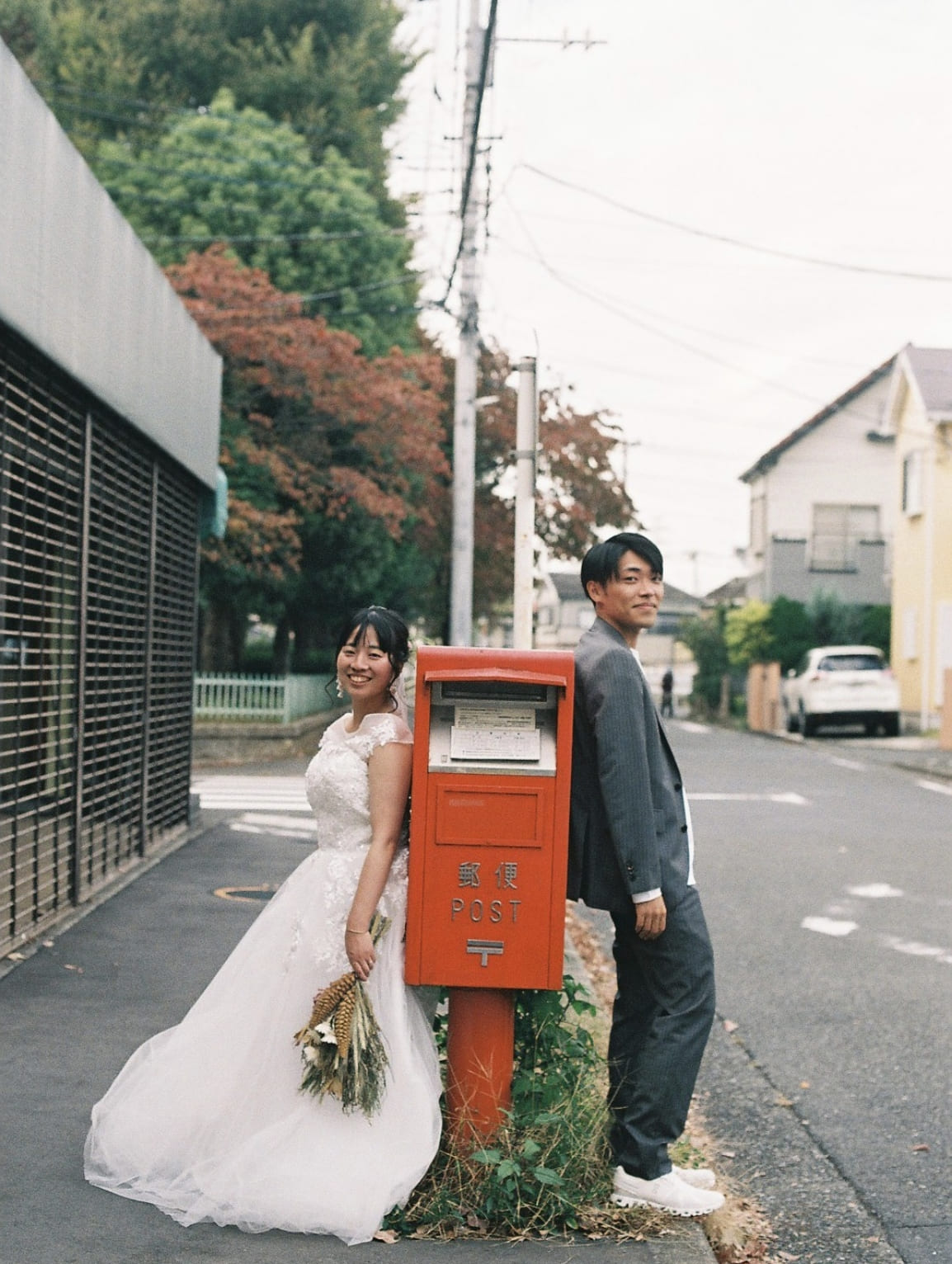 赤い郵便ポストと新郎新婦