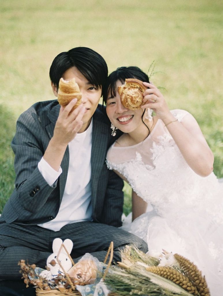 ドーナツを目元に重ねる新郎新婦