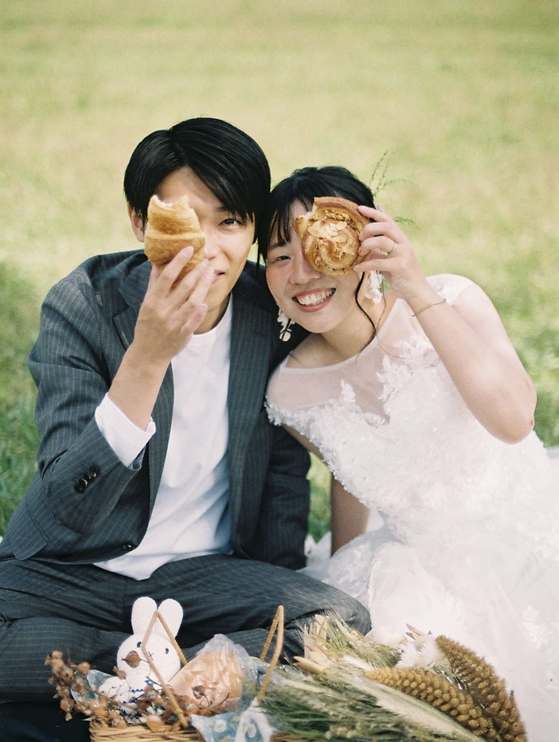 ドーナツを目元に重ねる新郎新婦