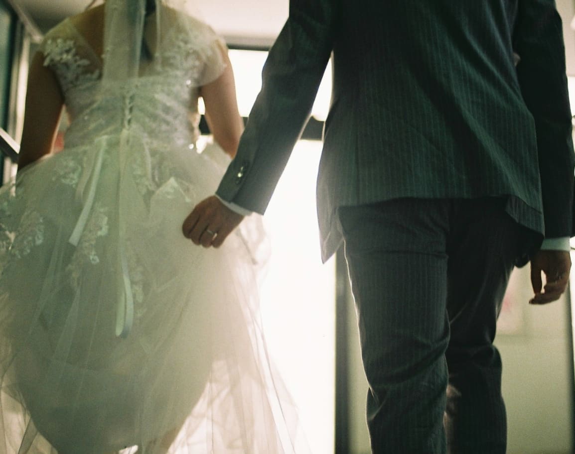 街角で手をつなぐ新郎新婦