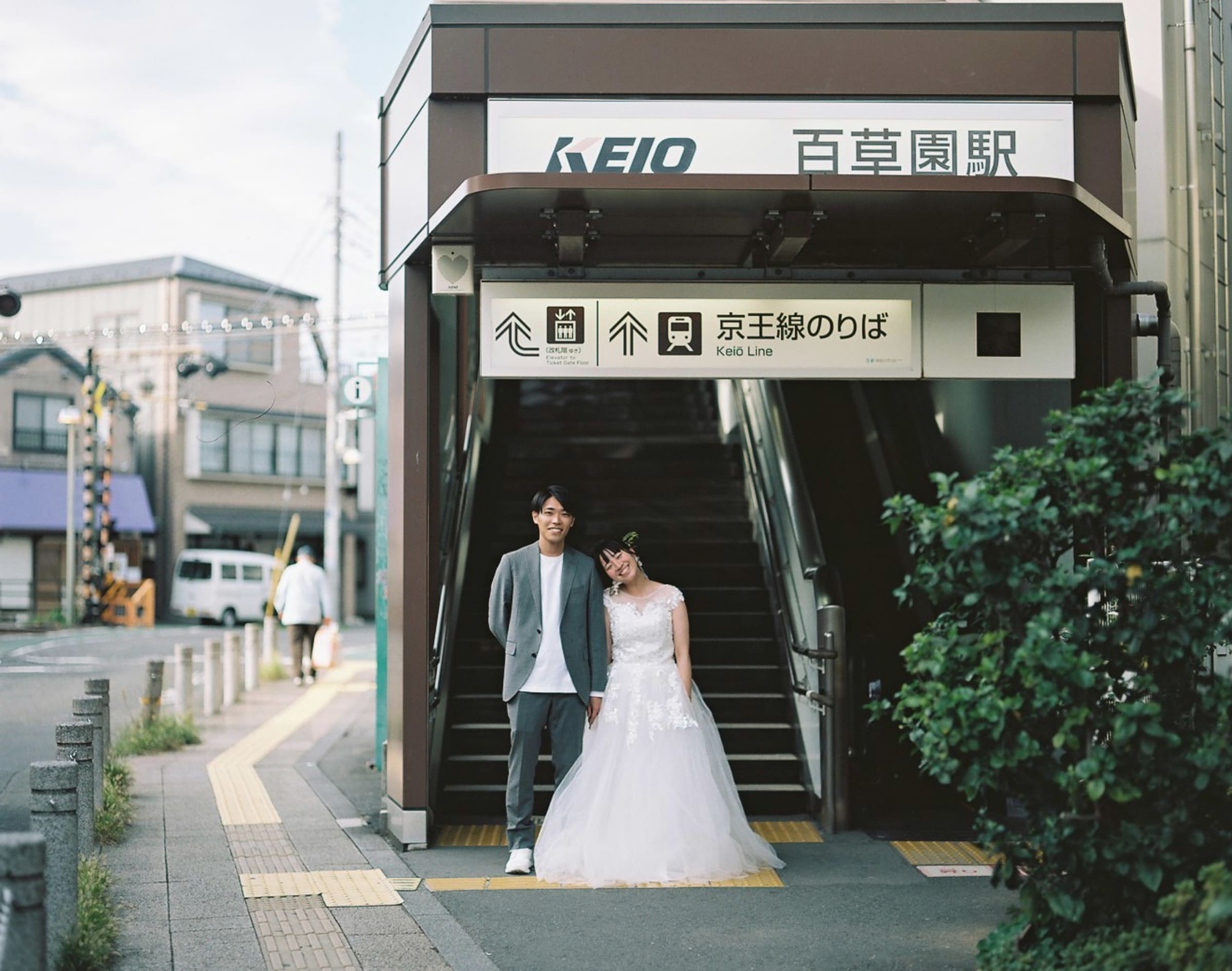 百草園駅前に立つ新郎新婦