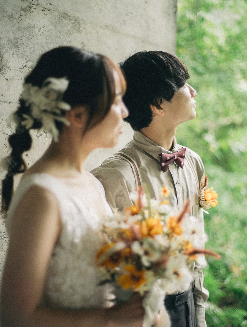 森を眺めて背中合わせに立つ新郎新婦