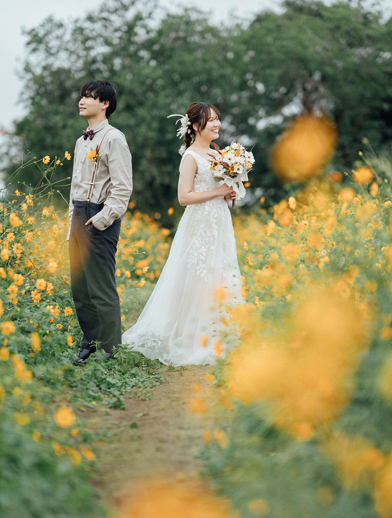 コスモス畑に立つ新郎新婦