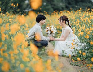 コスモス畑で向かい合う新郎新婦