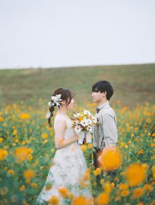 キバナコスモス畑で見つめ合う新郎新婦