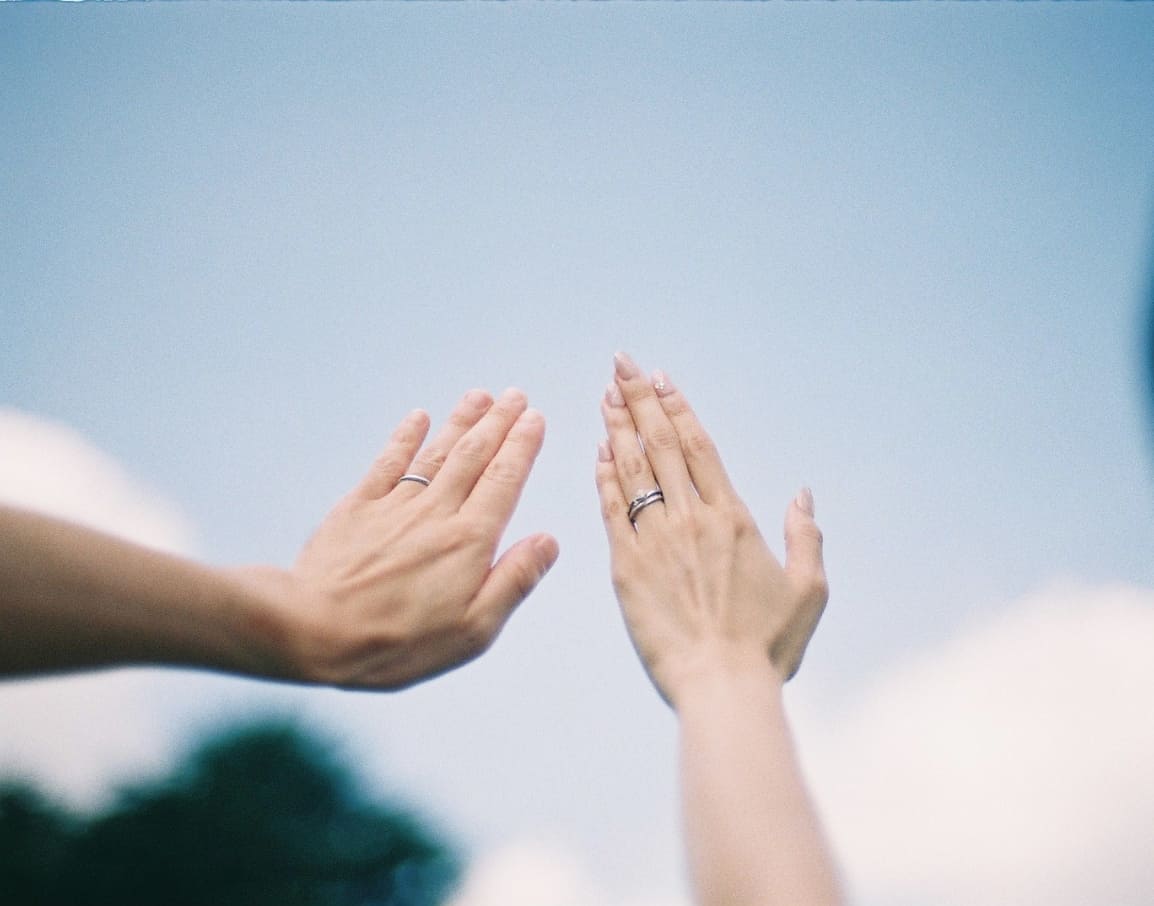 結婚指輪を見せる二人の手元