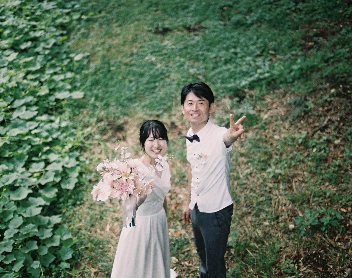 緑の小径で笑う新郎新婦