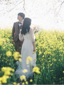 菜の花畑で寄り添う新郎新婦