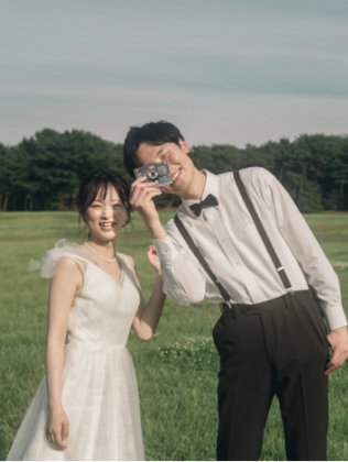芝生で小道具を楽しむ新郎新婦