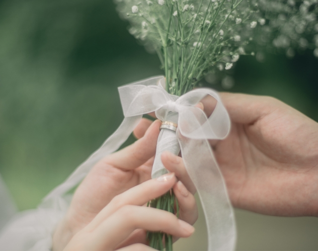 かすみ草のブーケに手を添える新郎新婦