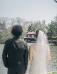 湖畔に並ぶウェディング姿の二人