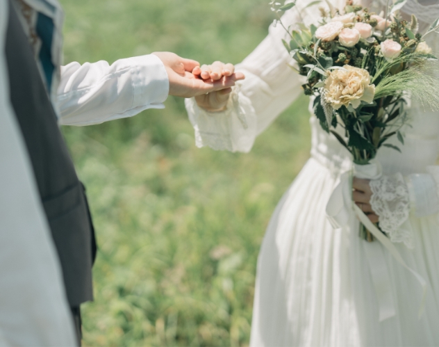 ブーケを持って手をつなぐ新郎新婦
