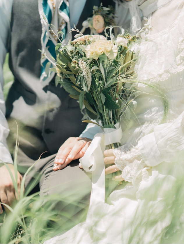 草原でブーケを抱える花嫁の手元