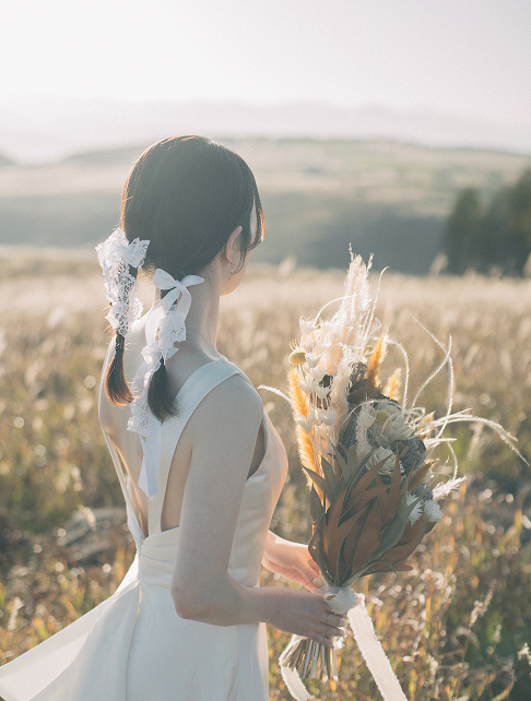 高原でブーケを抱える花嫁の横顔