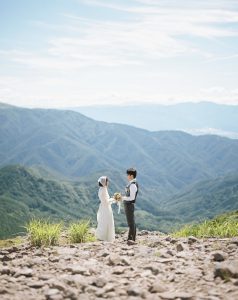 山並みを背に向かい合う新郎新婦