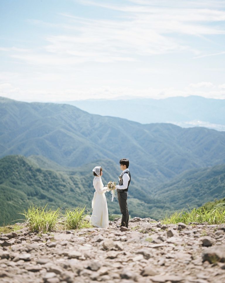 山並みを背に向かい合う新郎新婦