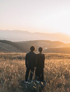 夕日を眺める新郎新婦の後ろ姿