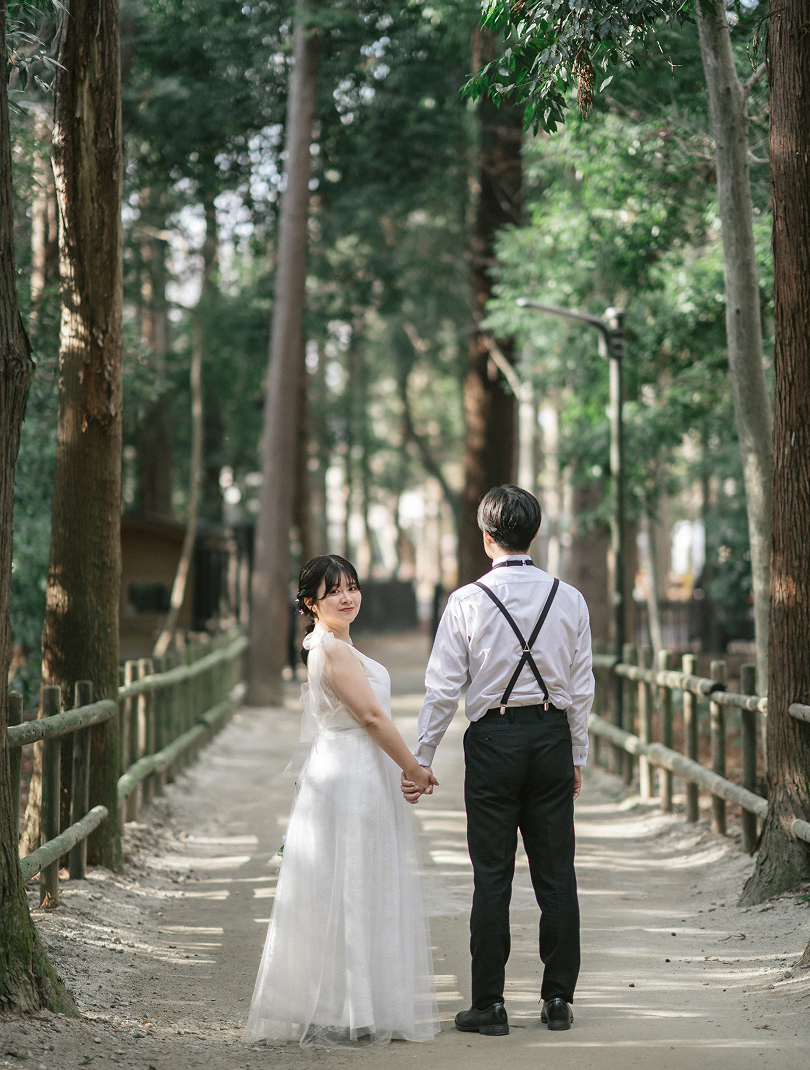 木立の橋で振り返る新郎新婦
