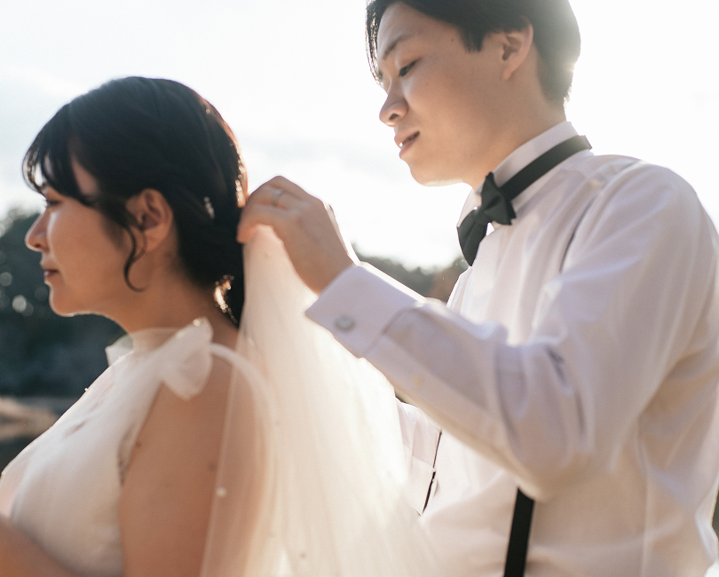 花嫁の肩のリボンを結ぶ新郎
