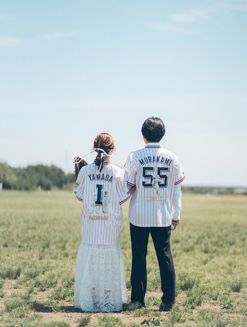 野球のユニフォームを着た新郎新婦の後ろ姿