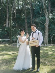 撮影小物を持って並ぶ新郎新婦