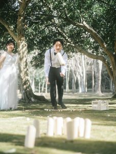 芝生でモルックを楽しむ新郎新婦
