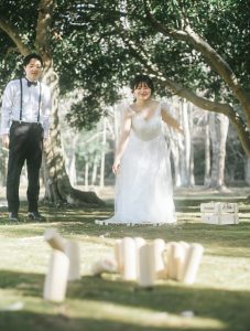モルックを投げる花嫁と見守る新郎