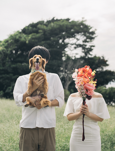 愛犬とブーケを掲げる新郎新婦