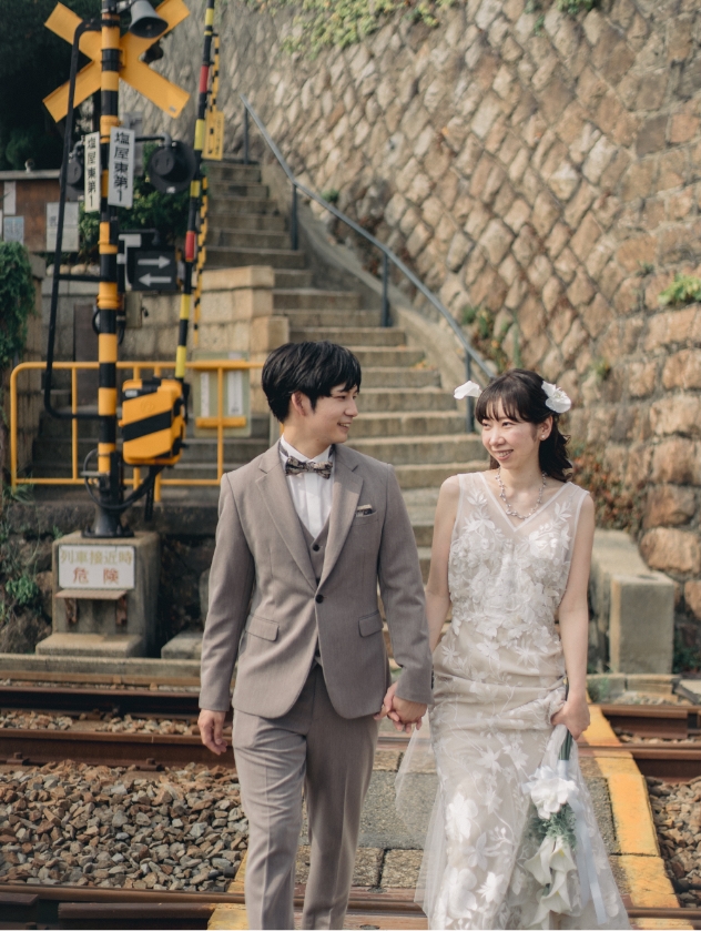 踏切に並んで立つ新郎新婦
