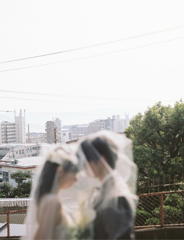 街並みを背景にベールをかぶる新郎新婦