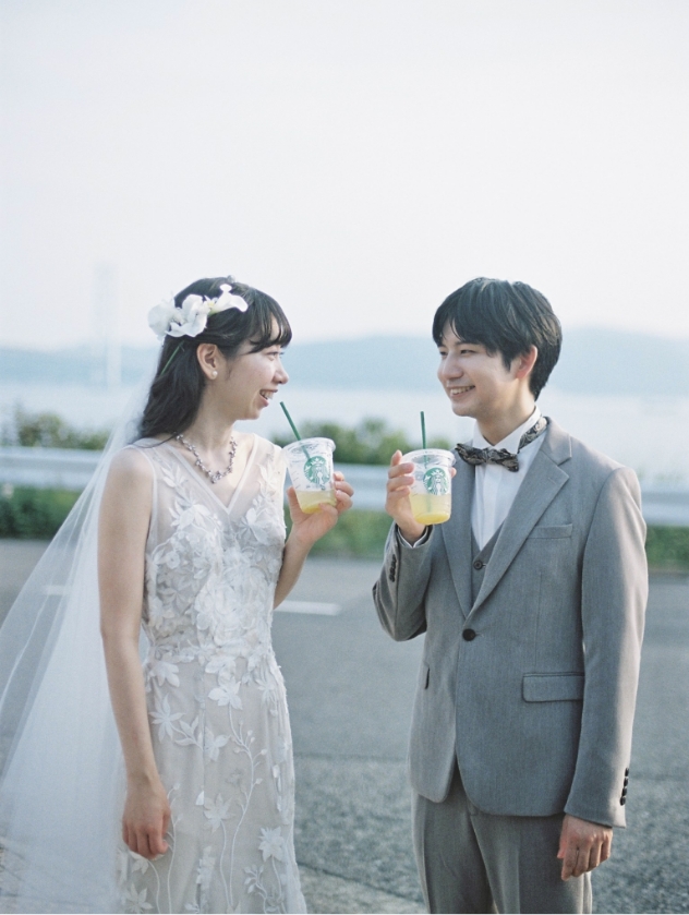 海を背景にドリンクを持つ新郎新婦