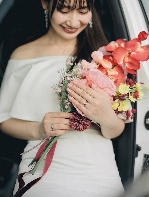 車のそばでブーケを抱える花嫁