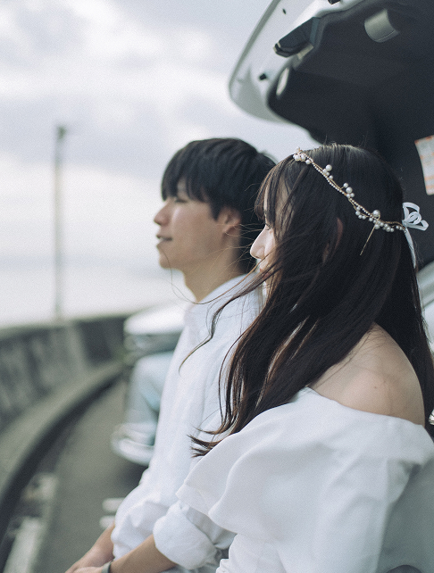 海辺で愛車に寄り添う新郎新婦