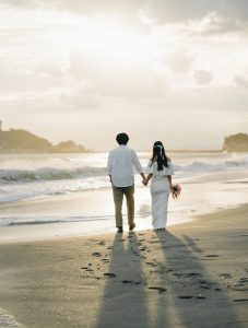 波打ち際を歩く新郎新婦の後ろ姿