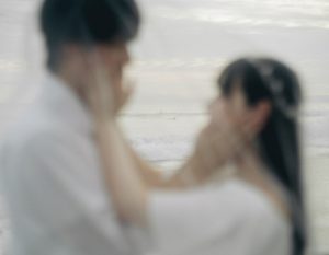 海を背景に見つめ合う新郎新婦