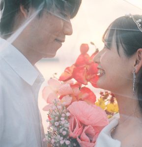 夕日の中で顔を寄せる新郎新婦