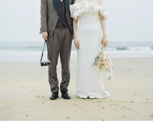久慈浜に並んで立つ新郎新婦