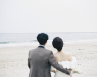 海を眺めて寄り添う新郎新婦