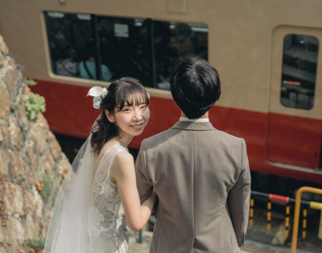 電車を背景に振り返る花嫁