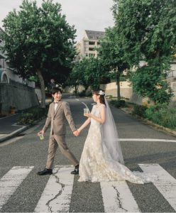 横断歩道を手をつないで渡る新郎新婦