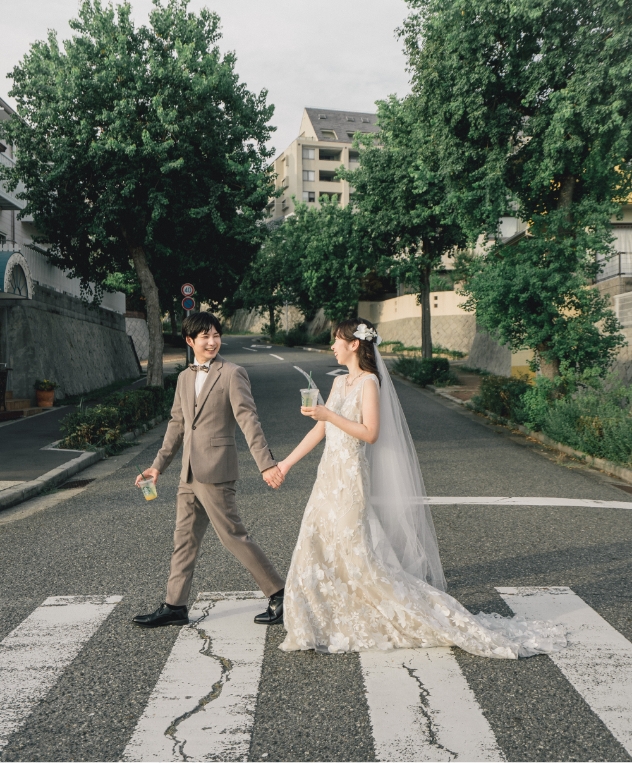 横断歩道を手をつないで渡る新郎新婦