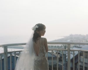 高台から海を眺める花嫁の後ろ姿