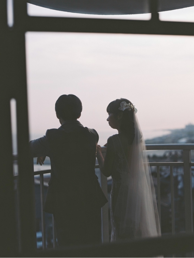 夕景の窓辺で向かい合う新郎新婦