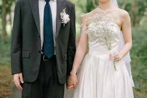 かすみ草のブーケを手に並ぶ新郎新婦