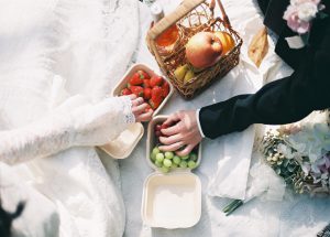 ピクニックの籠から果物を取る新郎新婦の手元