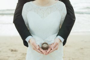木製のリングケースに納めた指輪を手にのせる新婦