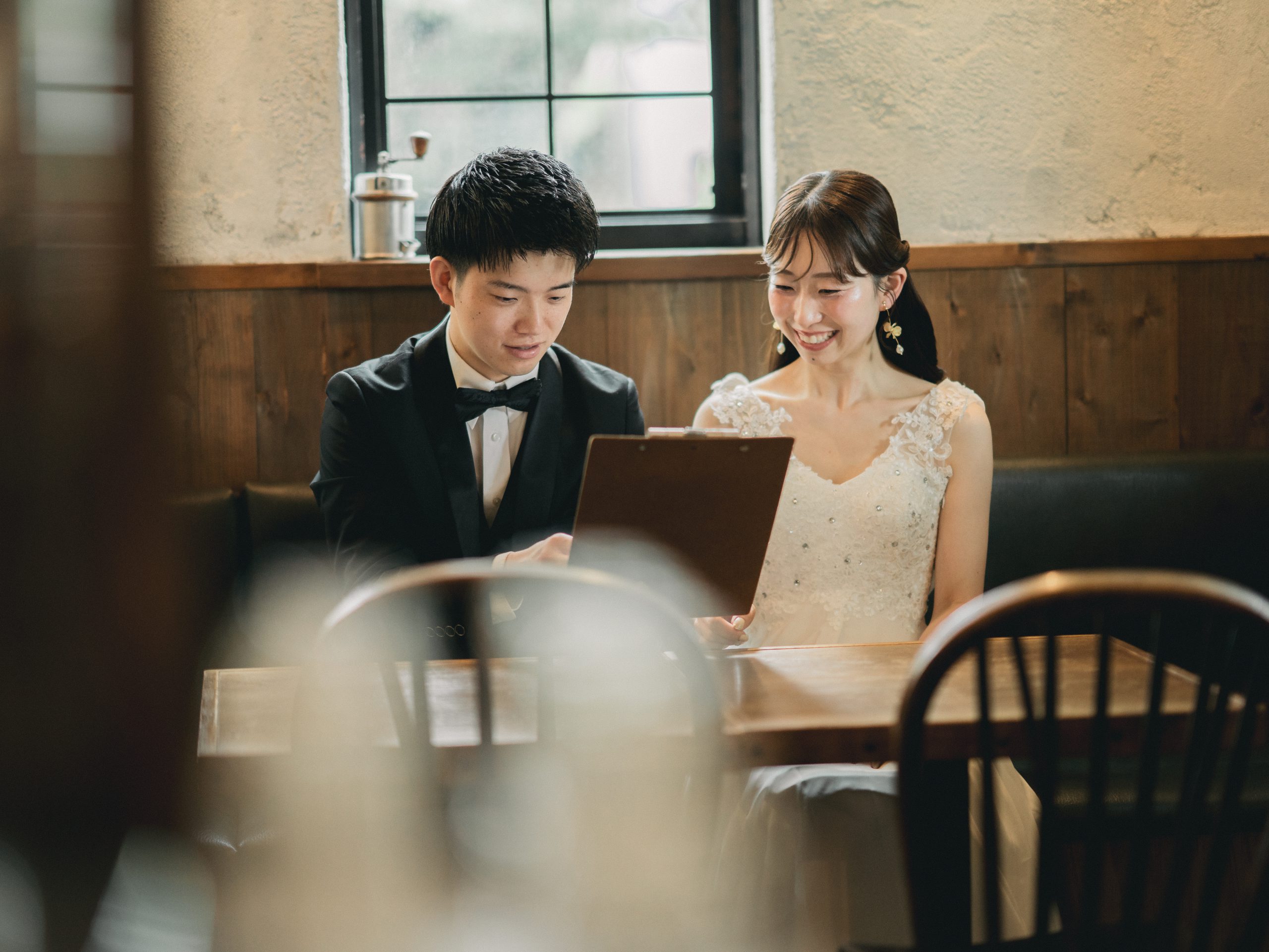 香豆珈琲のテーブルでメニューボードを見る新郎新婦