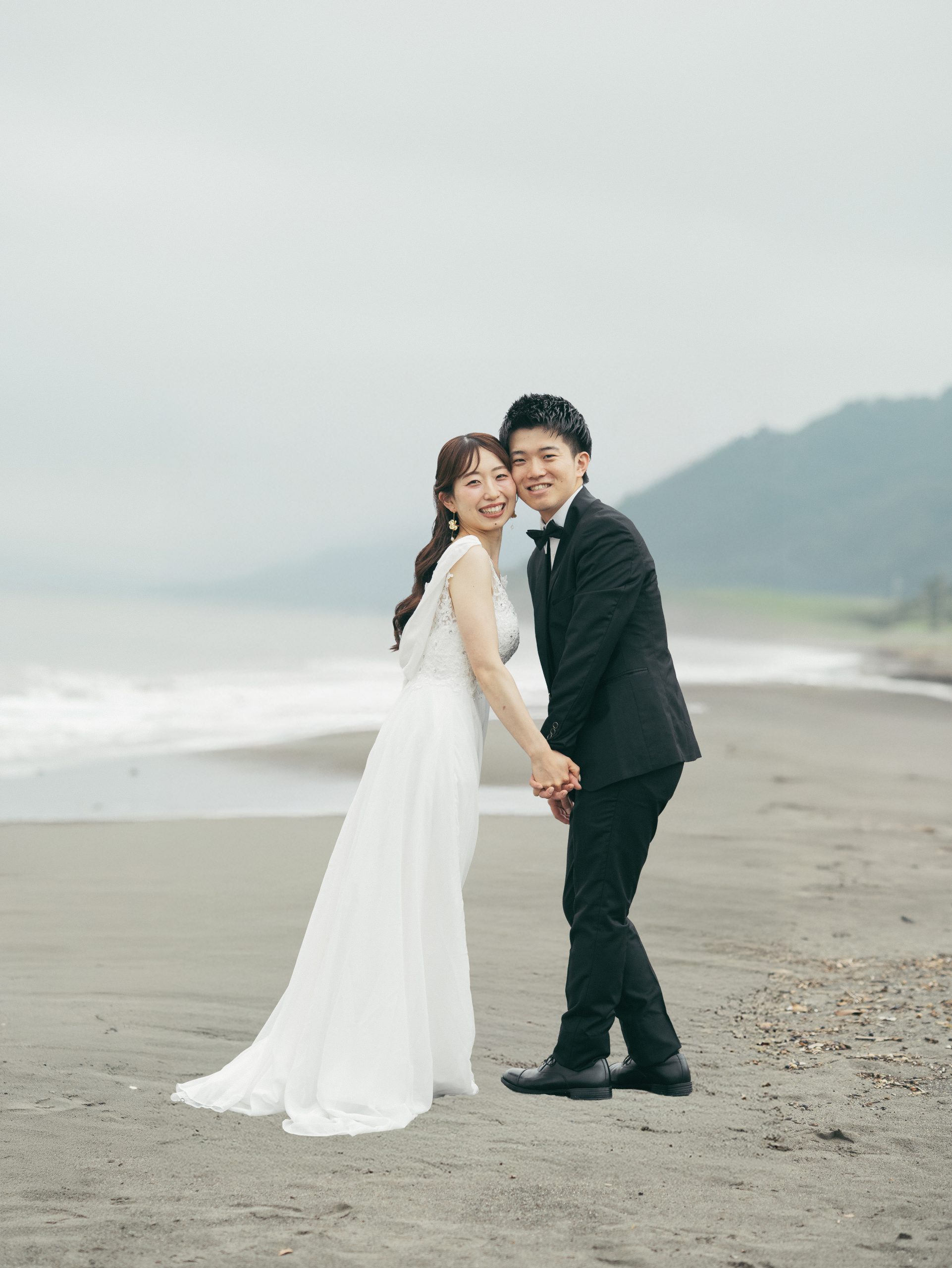 保田中央海岸で手をつないで微笑む新郎新婦