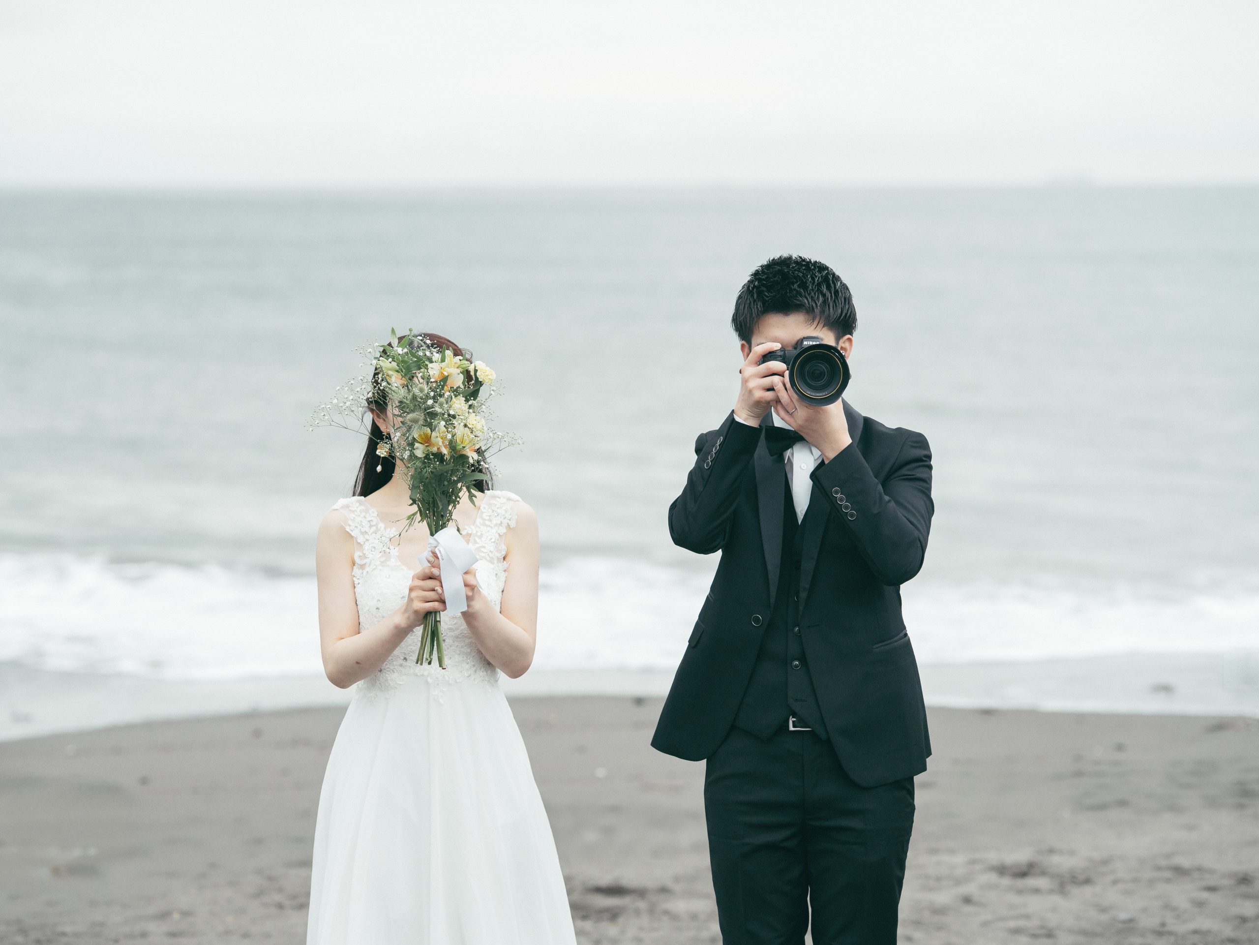 保田中央海岸でカメラとブーケを構える新郎新婦
